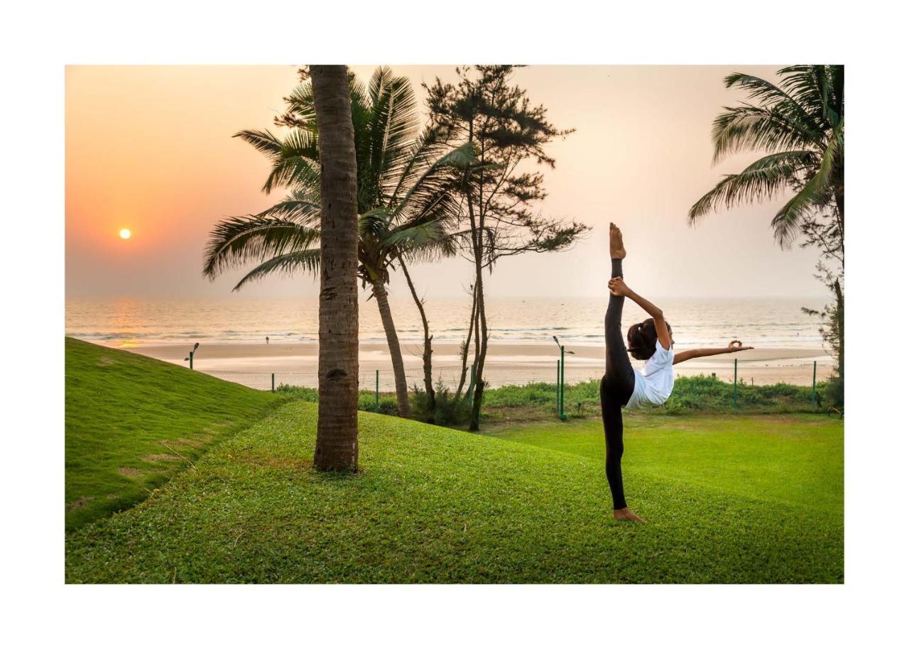 Caravela Beach Resort Varca Bagian luar foto A woman practicing yoga at the beach